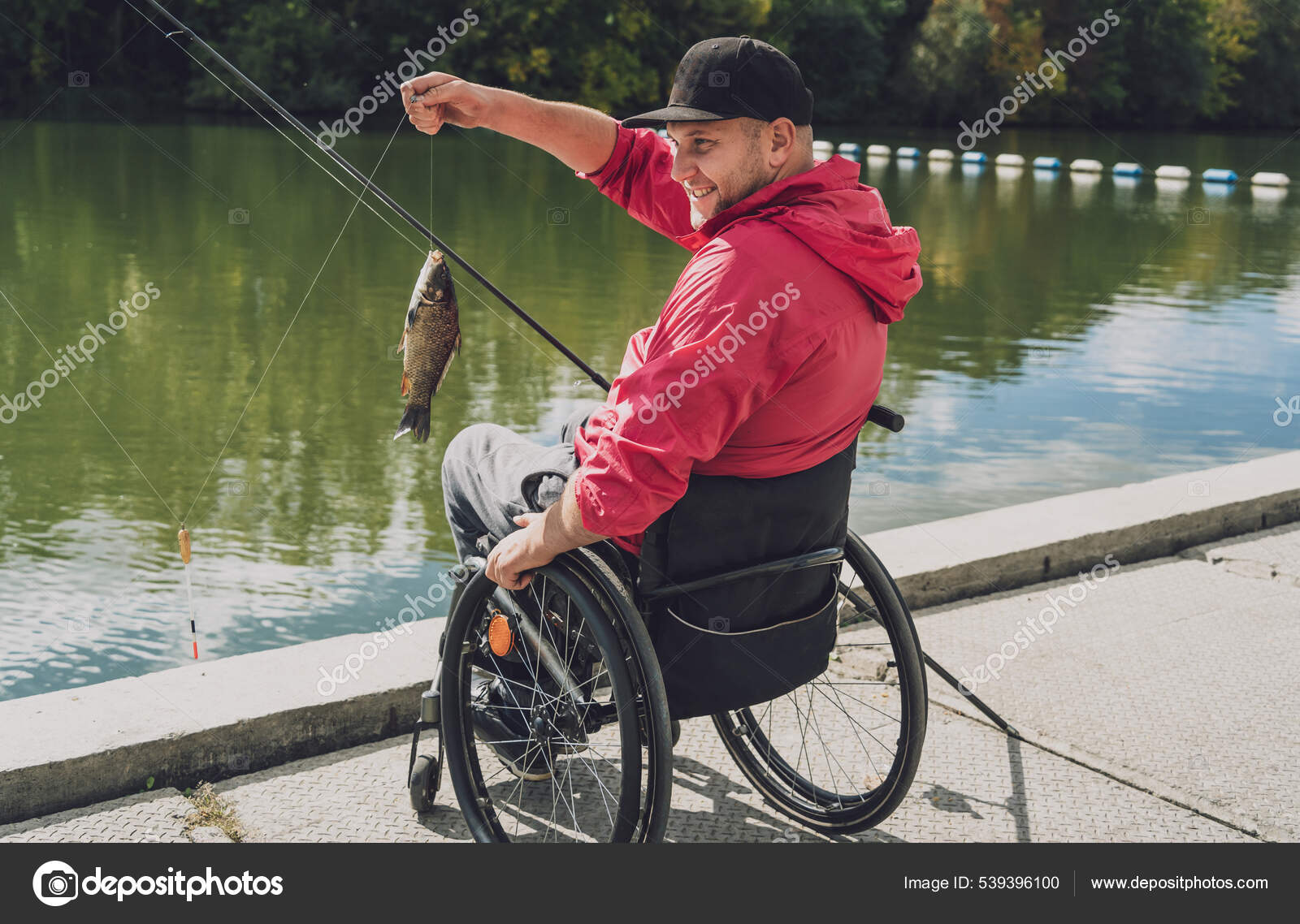 Person with a physical disability who uses wheelchair fishing from fishing  pier. — Stock Photo © Romaset #539396100