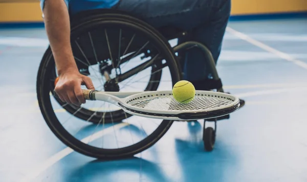 Hombre adulto con discapacidad física que utiliza silla de ruedas jugando al tenis en pista de tenis cubierta —  Fotos de Stock