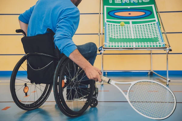 Hombre adulto con discapacidad física que utiliza silla de ruedas jugando al tenis en pista de tenis cubierta —  Fotos de Stock