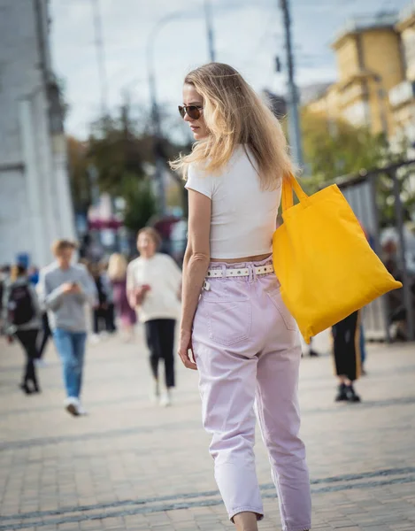 Şehrin arka planında keten çantalı güzel bir kadın..