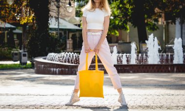 Şehrin arka planında keten çantalı güzel bir kadın..