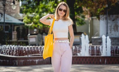 Şehrin arka planında keten çantalı güzel bir kadın..
