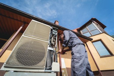 HVAC teknisyeni evde ısıtma ve soğutma sistemi hizmeti veriyor.