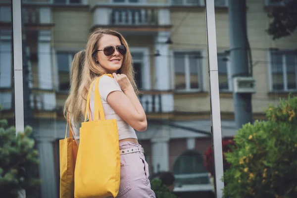 Joven hermosa mujer con bolsa ecológica de lino en el fondo de la ciudad. —  Fotos de Stock