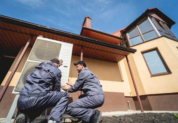 HVAC technicians servicing home heating and cooling system — Foto Stock