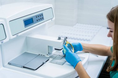 Laboratuvar asistanı parafin ağda doku yerleştirme makinesinde çalışıyor..