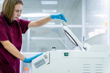 Laboratuvar asistanı modern laboratuvarda mikrodalga hibrit doku işlemcisi üzerinde çalışıyor..