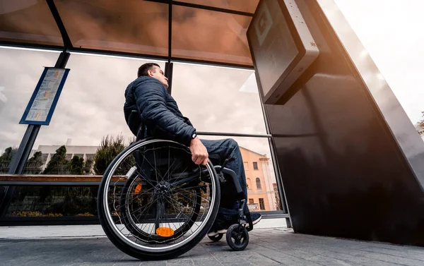 Persona con discapacidad física que espera el transporte urbano con una rampa accesible. —  Fotos de Stock