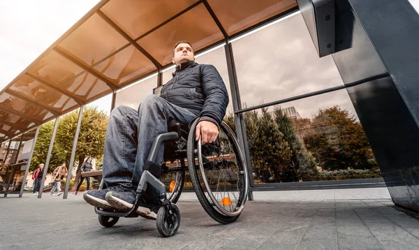 Osoba s tělesným postižením čeká na městskou dopravu s přístupnou rampou. — Stock fotografie