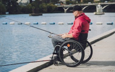 Balıkçı iskelesinden tekerlekli sandalyede balık tutan fiziksel engelli biri..