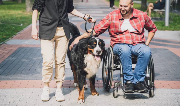 신체 장애가 있어서 개와 함께 휠체어를 타는 행복 한 젊은이. — 스톡 사진