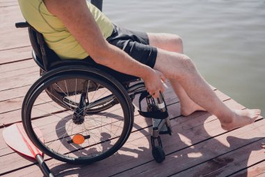 Tekerlekli sandalye kullanan fiziksel engelli kişi yemek masasına oturacak.