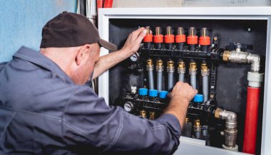 HVAC teknisyeni evde ısıtma ve soğutma sistemi hizmeti veriyor.