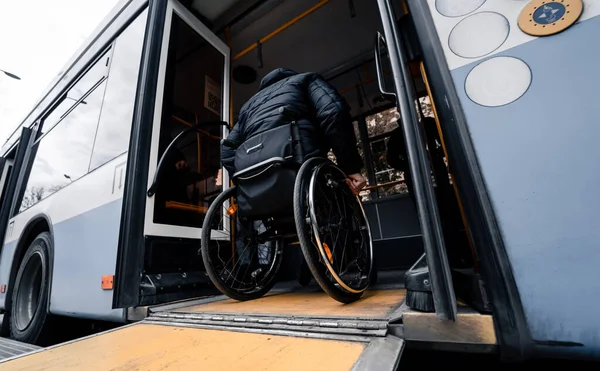 La persona con disabilità fisica entra nel trasporto pubblico con una rampa accessibile. — Foto Stock