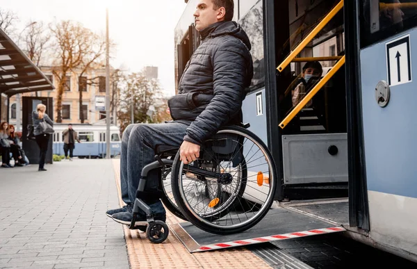 Persona con discapacidad física sale del transporte público con una rampa accesible. —  Fotos de Stock