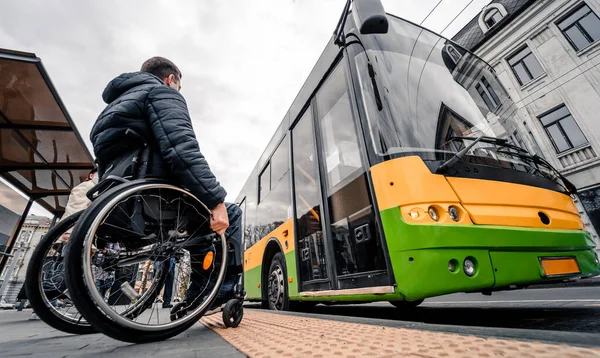 Persona con disabilità fisica in attesa di trasporto urbano con rampa accessibile. — Foto Stock