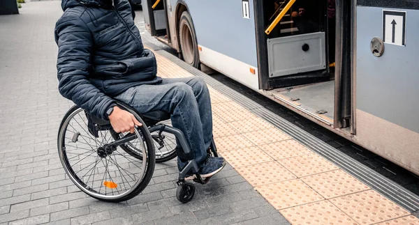 Pessoa com deficiência física entra em transporte público com uma rampa acessível. — Fotografia de Stock