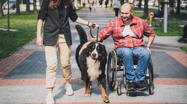 신체 장애가 있어서 개와 함께 휠체어를 타는 행복 한 젊은이. — 스톡 사진
