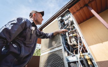 HVAC teknisyeni evde ısıtma ve soğutma sistemi hizmeti veriyor.