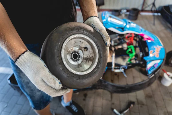 El mecánico ir kart servicio de carreras cambiar las ruedas —  Fotos de Stock