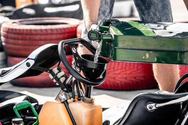 Mechanik jít kart závodní servis nalévá palivo do nádrže — Stock fotografie