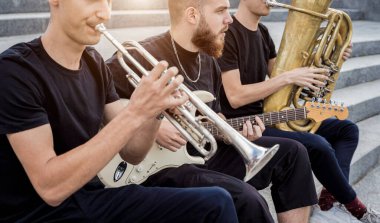 Genç sokak müzik grubu bir sürü enstrüman çalıyor.