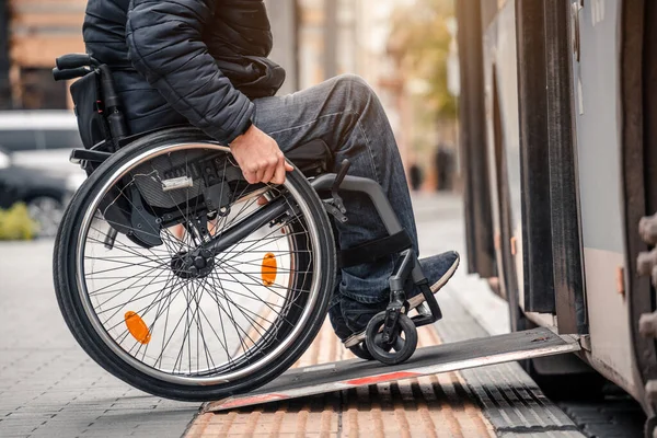 La persona con disabilità fisica entra nel trasporto pubblico con una rampa accessibile. — Foto Stock