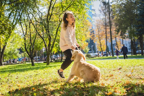 Ägaren spelar golden retriever hund i parken. — Stockfoto