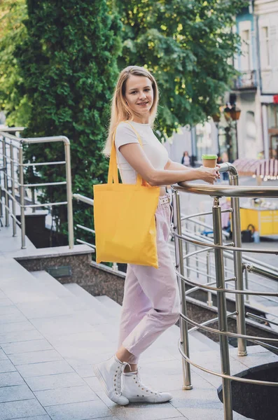 Молодая красивая женщина с льняной эко-сумкой на фоне города. — стоковое фото
