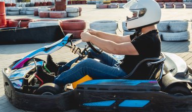 Genç bir adam pistte go kart kullanıyor.