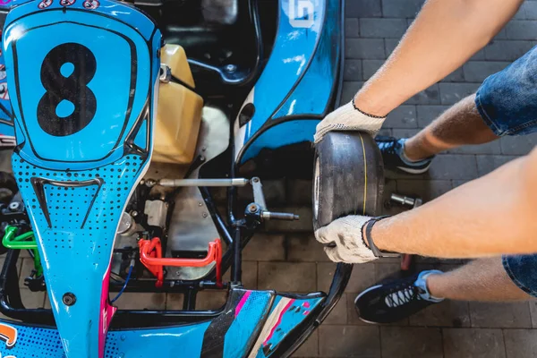 El mecánico ir kart servicio de carreras cambiar las ruedas — Foto de Stock