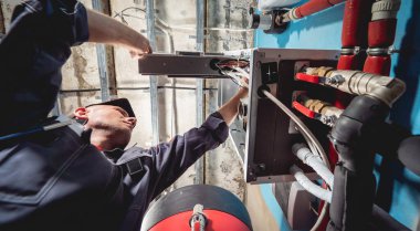 Klima teknisyeni klimayı kontrol ediyor.