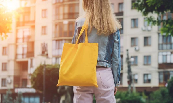 Joven hermosa mujer con bolsa ecológica de lino en el fondo de la ciudad. — Foto de Stock