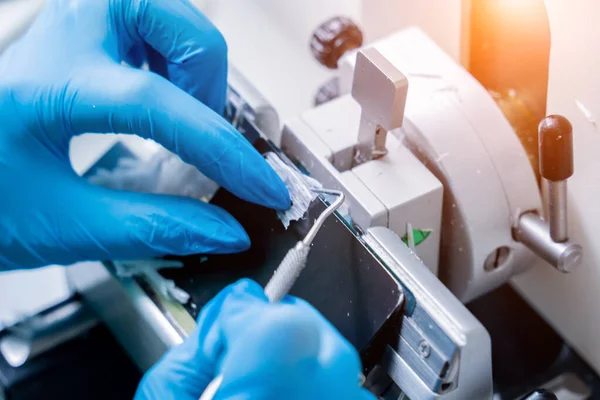 Assistant de laboratoire travaille sur une section de microtome rotatif et de faire des diapositives de microscope — Photo