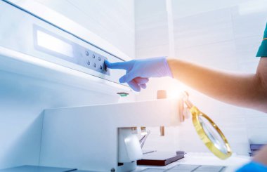 Laboratuvar asistanı parafin ağda doku yerleştirme makinesinde çalışıyor..