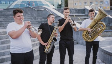 Genç sokak müzik grubu bir sürü enstrüman çalıyor.