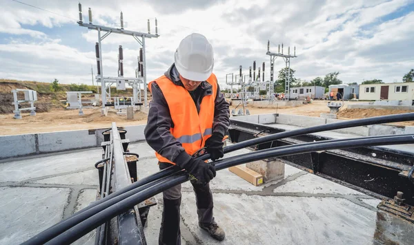 Deux ouvriers électriciens installant un câble haute tension — Photo