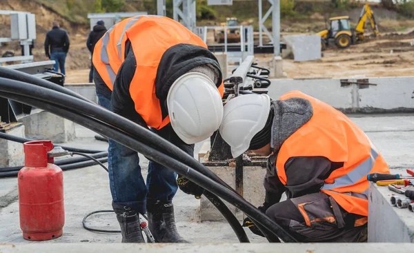 Två elektriker byggarbetare installera högspänningskabel — Stockfoto