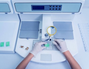 Laboratuvar asistanı parafin ağda doku yerleştirme makinesinde çalışıyor..