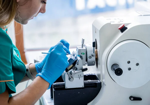 Laborassistentin arbeitet an einem rotierenden Mikrotomschnitt und fertigt Mikroskopobjekte — Stockfoto