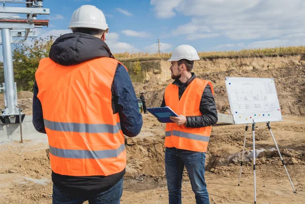 Två ingenjörer elektriker kontrollera understationen byggprocessen — Stockfoto