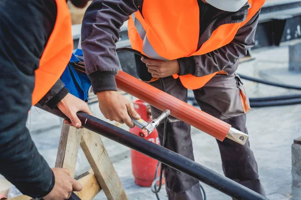 Två elektriker byggarbetare installera högspänningskabel — Stockfoto