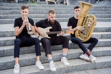 Genç sokak müzik grubu bir sürü enstrüman çalıyor.