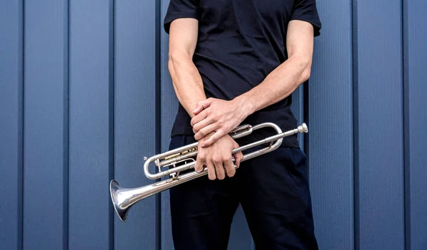 Young street musician playing the trumpet near the big blue wall — Fotografia de Stock