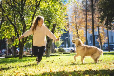 Sahibi parkta golden retriever köpeği oynuyor..