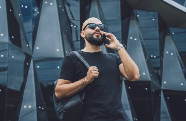 Modadan bir gencin portresi telefonda konuşuyor. Güzel, karanlık şehir arka planında.