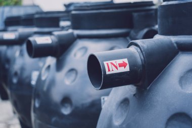 Üretici fabrikasındaki siyah plastik su deposu.