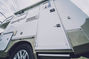 Travel camp trailer car with on the ground with grass