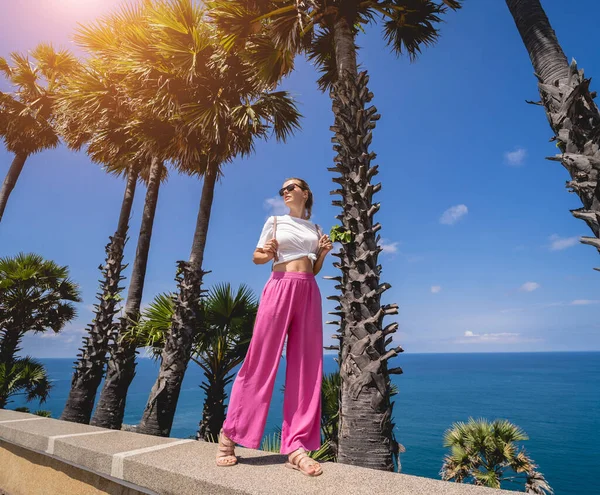 Young traveler woman at summer holiday vacation with beautiful palms and seascapes — Stock fotografie