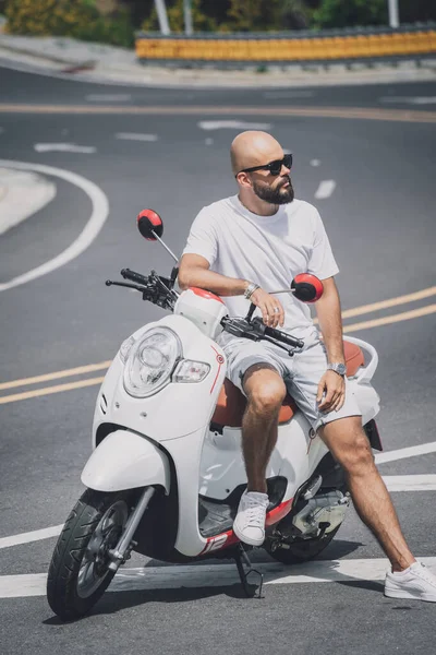 Stylish young man with his motorbike on the road — Stock Fotó